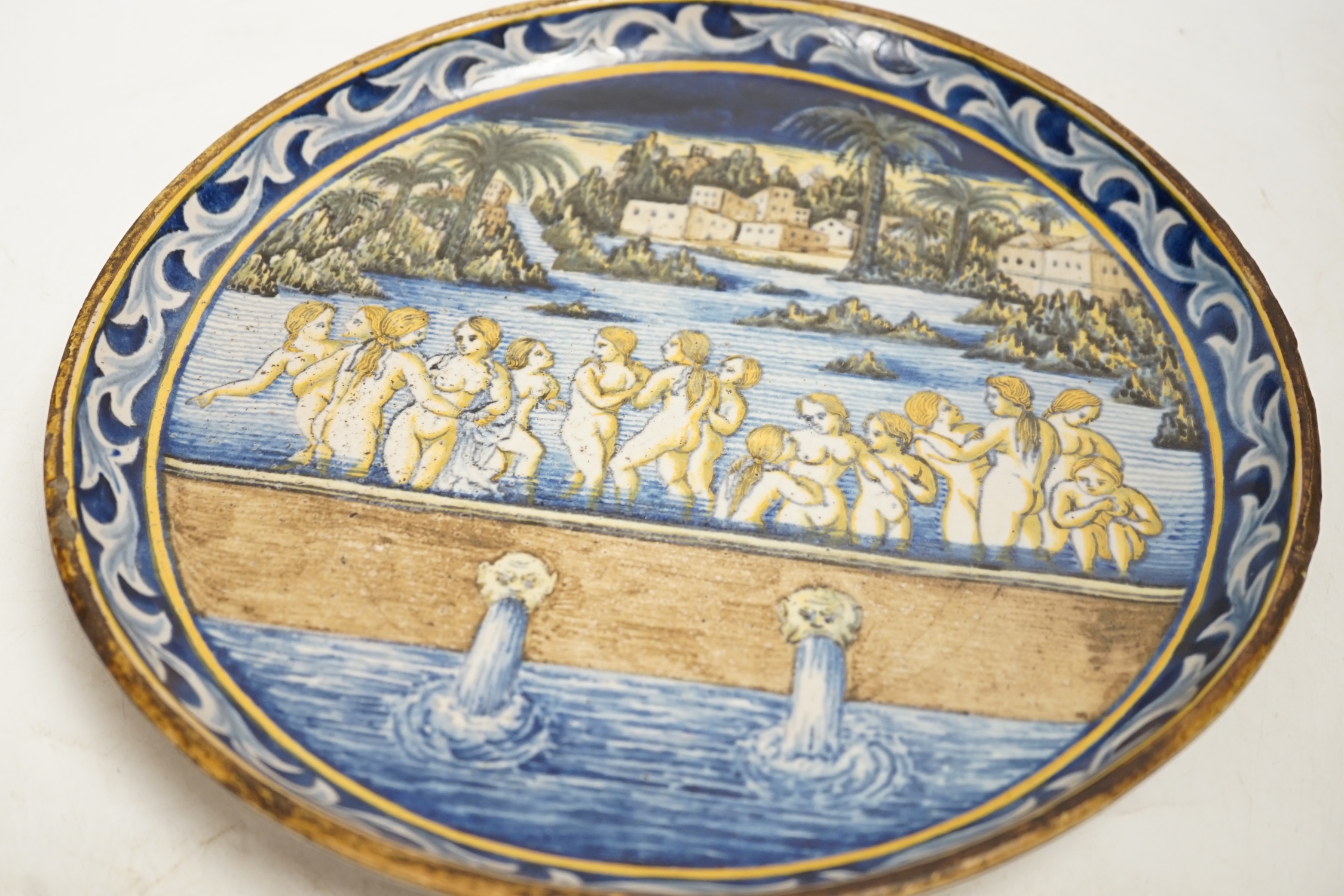 An 18th / 19th century Castelli maiolica plate, decorated with nude females bathing, 28.5cm diameter. Condition - fair to good